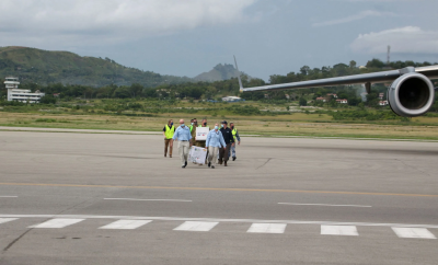 A group of people carrying boxes of aid on the tarmac