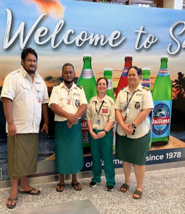 Group of four people standing together and smiling for the camera