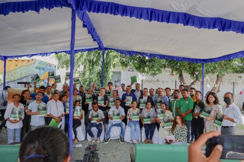 Group of people seated and smiling for the camera while holding reports